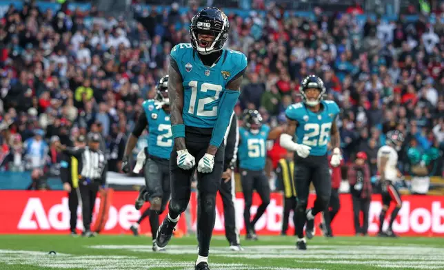 Jacksonville Jaguars wide receiver Travis Hunter (12) celebrates after making an interception during an NFL football game against Houston Texans in London, Sunday, Oct. 18, 2026. (AP Photo/Ian Walton)