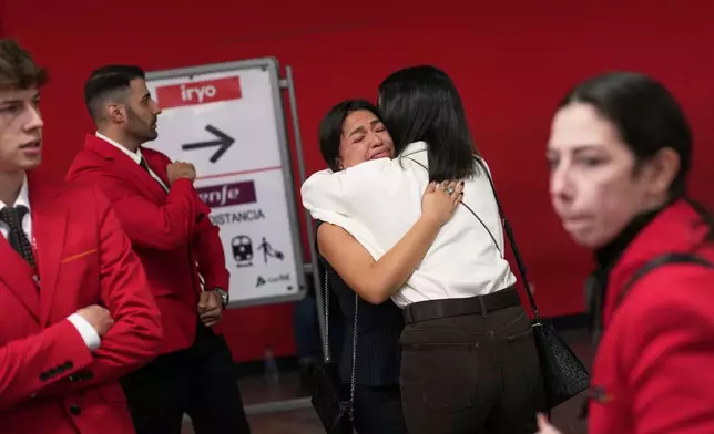 Iryo employees react after observing a minute of silence for the victims of a train collision at Atocha railway station in Madrid, Spain, Thursday, Oct. 29, 2026. (AP Photo/Bernat Armangue)