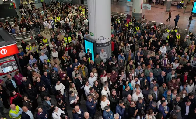 People observe a minute of silence in memory of the victims of a train collision at Atocha railway station in Madrid, Spain, Thursday, Oct. 29, 2026. (AP Photo/Bernat Armangue)