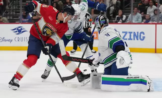 Vancouver Canucks goaltender Leevi Meriläinen (31) defends the goal against Florida Panthers left wing Brady Tkachuk (8) during the second period of an NHL hockey game, Thursday, Oct. 15, 2026, in Sunrise, Fla. (AP Photo/Lynne Sladky)
