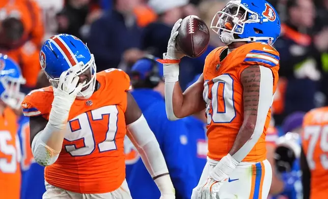 Denver Broncos defensive tackle Malcolm Roach (97) and inside linebacker Justin Strnad, right, celebrate Strnad's fumble recovery against Seattle Seahawks wide receiver Rashid Shaheed during the first half of an NFL football game in Denver, Thursday, Oct. 15, 2026. (AP Photo/David Zalubowski)