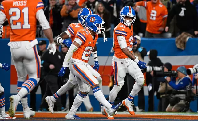Denver Broncos cornerback Kris Abrams-Draine, right, celebrates with safety Devon Key (26) and safety JL Skinner (34) after making an interception against the Seattle Seahawks during the second half of an NFL football game in Denver, Thursday, Oct. 15, 2026. (AP Photo/Geneva Heffernan)