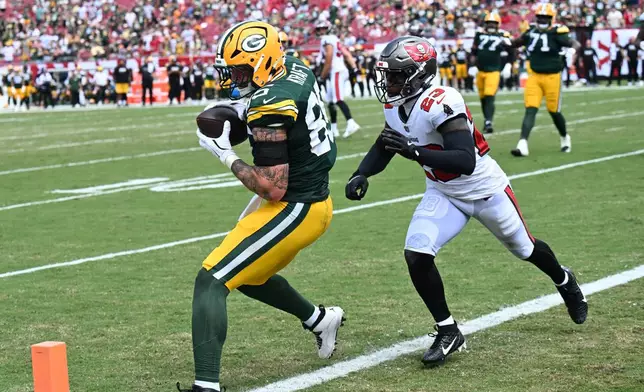Green Bay Packers tight end Tucker Kraft (85) makes a catch for a touchdown as Tampa Bay Buccaneers safety Tykee Smith (23) defends during the second half of an NFL football game against the Tampa Bay Buccaneers in Tampa, Fla., Wednesday, Sept. 30, 2026. (AP Photo/Jason Behnken)