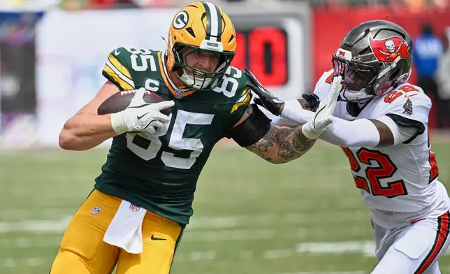 Tampa Bay Buccaneers cornerback Keionte Scott (22) grabs Green Bay Packers tight end Tucker Kraft (85) during the first half of an NFL football game in Tampa, Fla., Sunday, Oct. 4, 2026. (AP Photo/Jason Behnken)