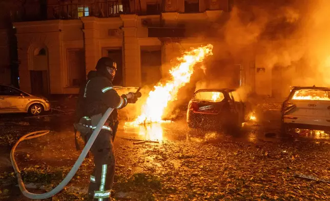 A firefighter puts out a fire following a Russian air attack at a residential building in Kharkiv, Ukraine, Tuesday, Oct. 13, 2026. (AP Photo/Andrii Marienko)