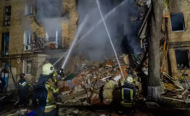 Firefighters put out a fire following a Russian air attack on a residential building in Kharkiv, Ukraine, Tuesday, Oct. 13, 2026. (AP Photo/Andrii Marienko)