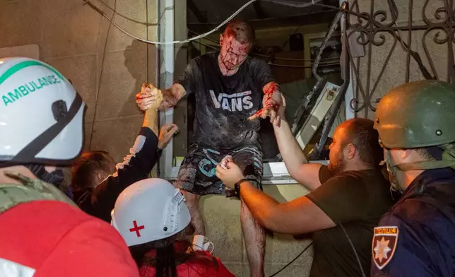 Rescuers evacuate an injured civilian after a residential building was hit following a Russian air attack in Kharkiv, Ukraine, Tuesday, Oct. 13, 2026. (AP Photo/Andrii Marienko)