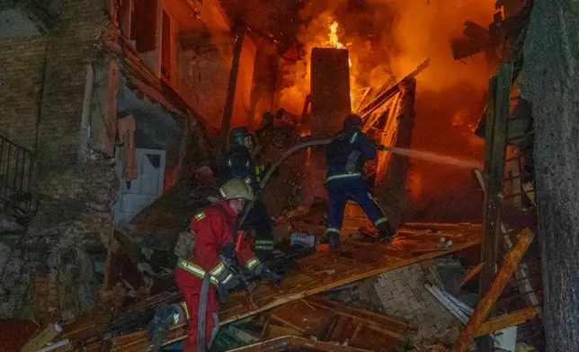 Firefighters put out a fire following a Russian air attack on a residential building in Kharkiv, Ukraine, Tuesday, Oct. 13, 2026. (AP Photo/Andrii Marienko)
