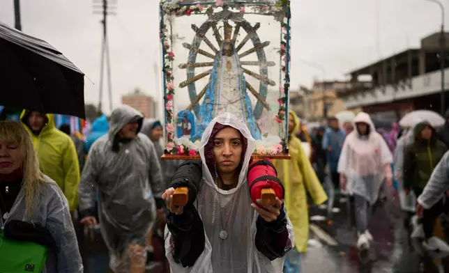 Rocio Bucci carries an image of the Virgin of Lujan while taking part in the annual procession to the Basilica of Lujan in Buenos Aires, Argentina, Saturday, Oct. 3, 2026. (AP Photo/Rodrigo Abd)