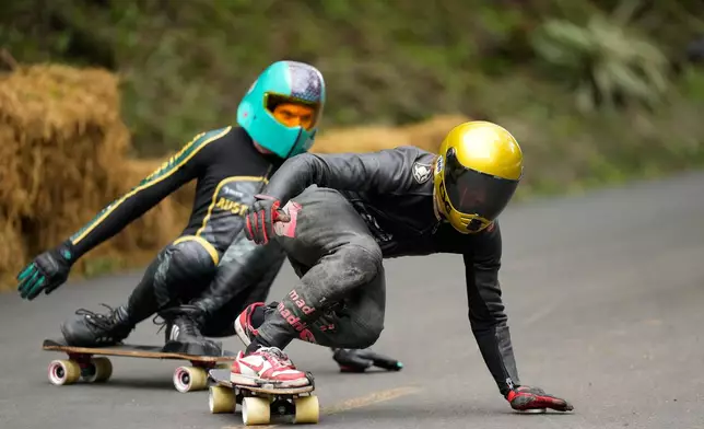 Spain's skateboarder Oscar Rodriguez, right, practices downhill at the Cerro Lambare venue in Asuncion, Paraguay, Sunday, Oct. 4, 2026, ahead of the World Skate Championship. (AP Photo/Jorge Saenz)