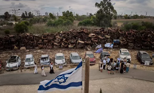 People visit a memorial made up of the vehicles that were burned and damaged during the Oct. 7 cross-border attack by Hamas militants three years prior, on the outskirts of Netivot in southern Israel, Wednesday, Sept. 30, 2026. (AP Photo/Oded Balilty)