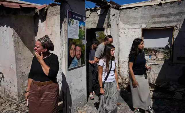 Visitors look at the damage inside the home of Nirel Zini and his partner Niv Raviv, who were killed three years prior in the Oct. 7 attack by Hamas in Kibbutz Kfar Aza, southern Israel, Friday, Oct. 2, 2026. (AP Photo/Oded Balilty)