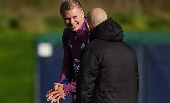 Manchester City's Erling Haaland chats with manager Enzo Maresca during a training session Tuesday, Oct. 13, 2026, in Manchester, England, a day ahead of their Champions League soccer match against Paris Saint-Germain. (Martin Rickett/PA via AP)