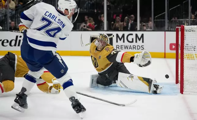 Tampa Bay Lightning defenseman John Carlson (74) scores against Vegas Golden Knights goaltender Carter Hart (79) during the first period of an NHL hockey game Tuesday, Oct. 20, 2026, in Las Vegas. (AP Photo/John Locher)