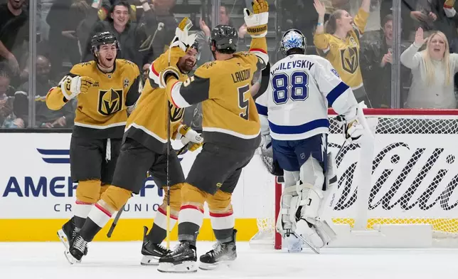 Vegas Golden Knights right wing Mark Stone, second from left, celebrates after scoring against the Tampa Bay Lightning during the first period of an NHL hockey game Tuesday, Oct. 20, 2026, in Las Vegas. (AP Photo/John Locher)