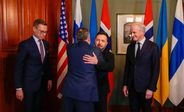 Ukrainian President Volodymyr Zelenskyy, center, hugs U.S. envoy Steve Witkoff as Norwegian Prime Minister Jonas Gahr Støre, right, and Finnish President Alexander Stubb look on, in Oslo, Norway, Tuesday, Oct. 20, 2026. (Heiko Junge/Pool Photo via AP)