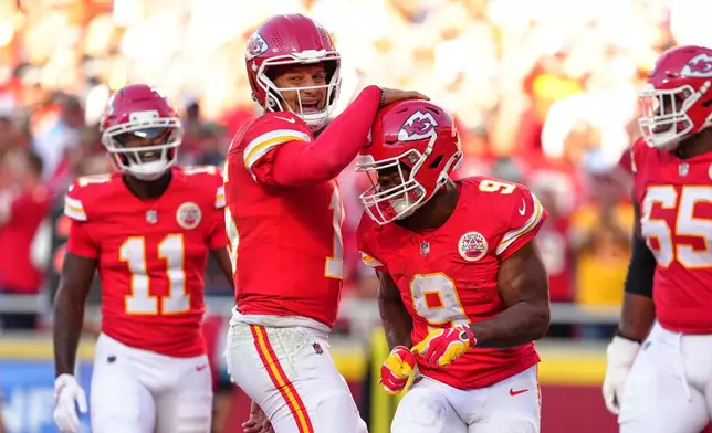 Kansas City Chiefs quarterback Patrick Mahomes, center left, and Kenneth Walker III (9) celebrate a touchdown scored on a rushing play by Walker III during the first half of an NFL football game against the Los Angeles Chargers in Kansas City, Mo., Sunday, Oct. 18, 2026. (AP Photo/Ed Zurga)