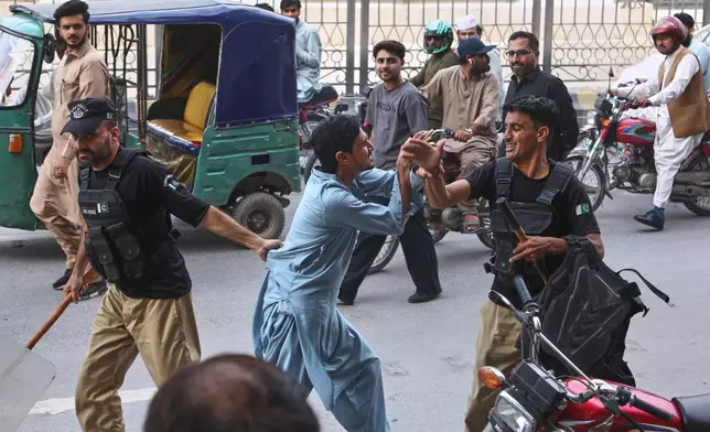 Police officers detain a supporters of imprisoned former Prime Minister Imran Khan's party during a protest against the Pakistani president declared a state of emergency in northwestern Khyber Pakhtunkhwa province and suspended its government, in Peshawar, Pakistan, Monday, Oct. 12, 2026. (AP Photo/Muhammad Zubair)