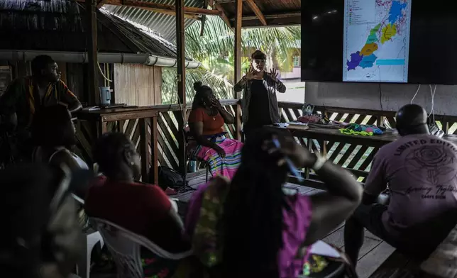 Sara Ramirez, a researcher working for the Association of Saamaka Communities, talks with a group about satellite analysis in Nieuw Aurora, Suriname, Tuesday, Sept. 29, 2026. (AP Photo/Ivan Valencia)