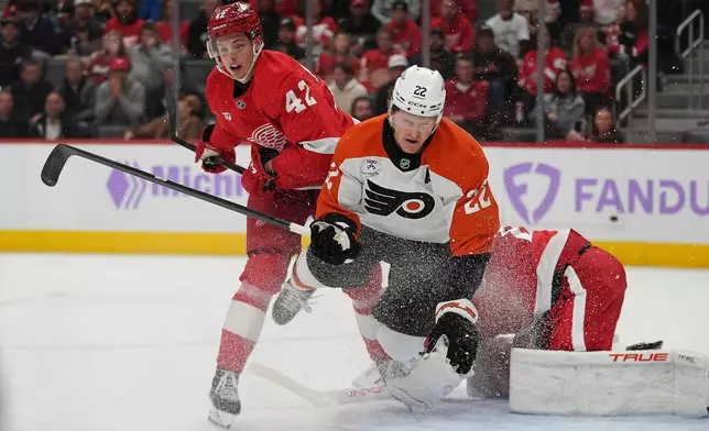 Philadelphia Flyers center Christian Dvorak (22) is taken to the ice as Detroit Red Wings' Anton Johansson (42) defends in the second period of an NHL hockey game Thursday, Oct. 15, 2026, in Detroit. (AP Photo/Paul Sancya)