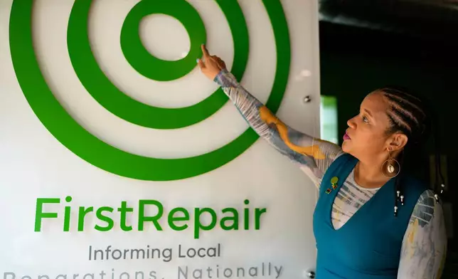 Founder and Executive director of FirstRepair, Robin Rue Simmons points FirstRepair logo as she talks at her office Monday, Aug. 10, 2026, in Evanston, Ill. (AP Photo/Nam Y. Huh)