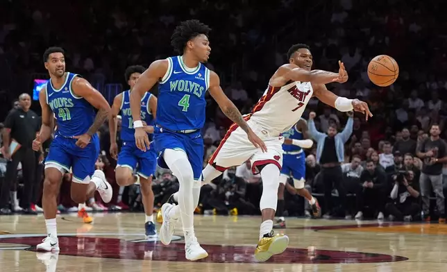 Miami Heat forward Giannis Antetokounmpo (7) passes as Minnesota Timberwolves guard Terrence Shannon Jr. (4) and forward Trey Lyles (41) run down court during the first half of an NBA basketball game, Wednesday, Oct. 21, 2026, in Miami. (AP Photo/Rebecca Blackwell)