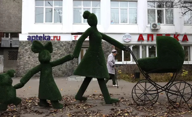 An elderly woman walks past a pharmacy in Shelekhov outside Irkutsk, Russia, on Thursday, Oct. 8, 2026. (AP Photo)