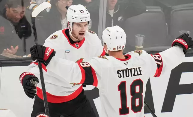 Ottawa Senators' Drake Batherson, left, is congratulated by Tim Stützle (18) after scoring against Boston Bruins' Jeremy Swayman during the second period of an NHL hockey game, Monday, Oct. 5, 2026, in Boston. (AP Photo/Charles Krupa)