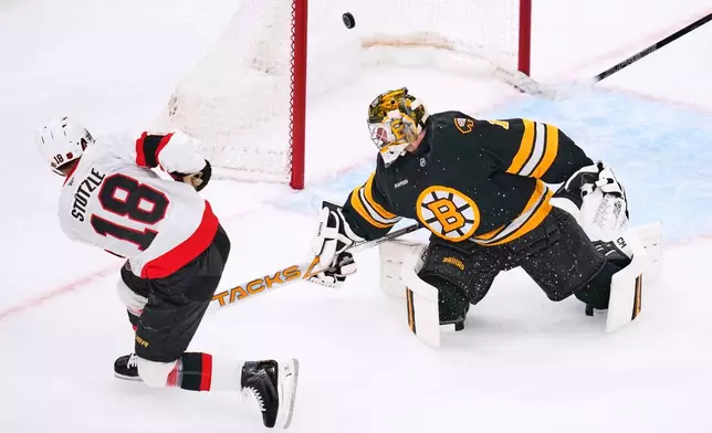 Ottawa Senators' Tim Stützle (18) scores against Boston Bruins' Jeremy Swayman, right, during the first period of an NHL hockey game, Monday, Oct. 5, 2026, in Boston. (AP Photo/Charles Krupa)