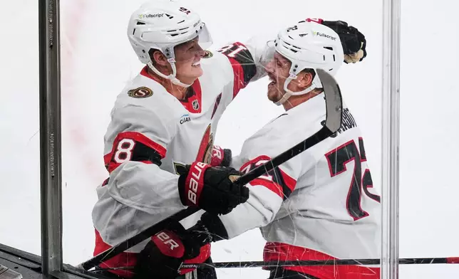 Ottawa Senators' Tim Stützle, left, is congratulated by Thomas Chabot, right, after scoring against Boston Bruins' Jeremy Swayman during the first period of an NHL hockey game, Monday, Oct. 5, 2026, in Boston. (AP Photo/Charles Krupa)