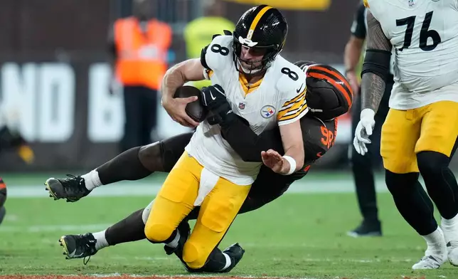 Pittsburgh Steelers quarterback Aaron Rodgers is tackled by Cleveland Browns defensive end Adin Huntington during the second half of an NFL football game in Cleveland, Thursday, Oct. 1, 2026. (AP Photo/Sue Ogrocki)