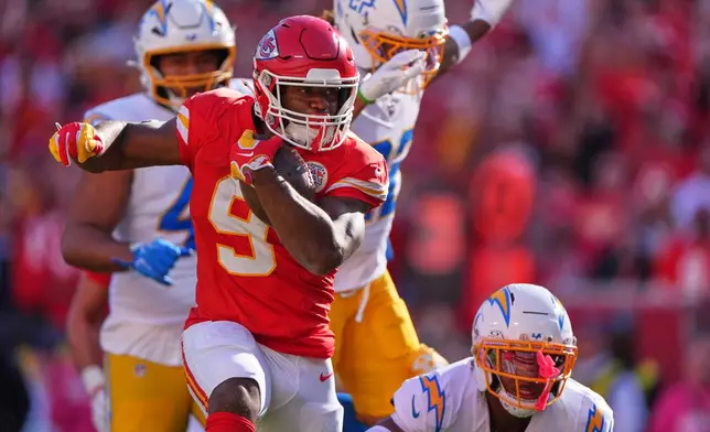 Kansas City Chiefs running back Kenneth Walker III (9) rushes for a touchdown as Los Angeles Chargers players give chase during the first half of an NFL football game in Kansas City, Mo., Sunday, Oct. 18, 2026. (AP Photo/Charlie Riedel)