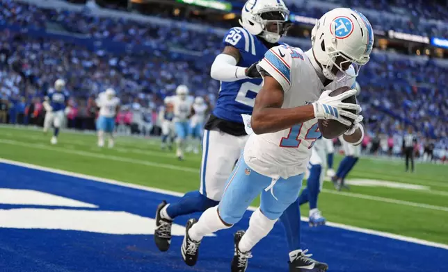 Tennessee Titans wide receiver Carnell Tate (14) catches a touchdown pass in the end zone past Indianapolis Colts cornerback Cam Taylor-Britt (29) during the second half of an NFL football game Sunday, Oct. 18, 2026, in Indianapolis. (AP Photo/Jeff Roberson)