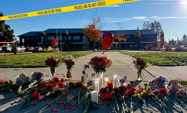 Flowers and candles are placed at a makeshift memorial at Silver Rail Elementary School in Bend, Ore., on Friday, Oct. 16, 2026, a day after a deadly shooting. (AP Photo/Haven Daley)