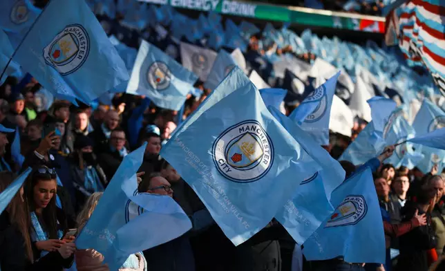 FILE - Manchester City fans wave the team's flag prior to the League Cup soccer match final between Aston Villa and Manchester City, at Wembley stadium, in London, England, Sunday, March 1, 2020. (AP Photo/Ian Walton, File)