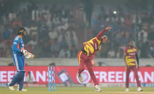 West Indies' Roston Chase, center, bowls a delivery during the fourth T20 cricket match between India and West Indies in Hyderabad, India, Wednesday, Oct. 14, 2026. (AP Photo/Mahesh Kumar A.)