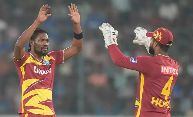 West Indies' Keemo Paul, left, celebrate with captain Shai Hope the wicket of India's Sanju Samson during the fourth T20 cricket match between India and West Indies in Hyderabad, India, Wednesday, Oct. 14, 2026. (AP Photo/Mahesh Kumar A.)