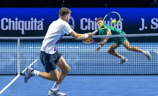Switzerland's Jerome Kym, foreground, plays a shot against the United States' Ben Shelton during their match at the Swiss Indoors tennis tournament at the St. Jakobshalle in Basel, Switzerland, Thursday, Oct. 29, 2026. (Georgios Kefalas/Keystone via AP)