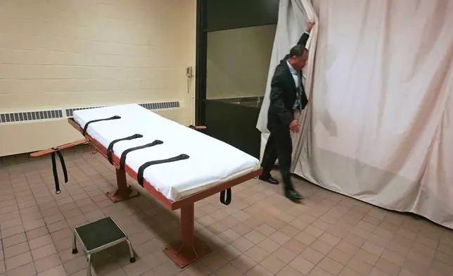 FILE - Larry Greene, the public information director of the Southern Ohio Correctional Facility, demonstrates how a curtain is pulled between the death chamber and witness room at the prison in Lucasville, Ohio, in November 2005. (AP Photo/Kiichiro Sato, File)