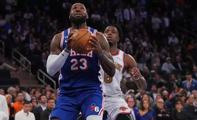 Philadelphia 76ers forward LeBron James (23) drives as New York Knicks forward Og Anunoby defends during the second half of an NBA basketball game Tuesday, Oct. 20, 2026, in New York. (AP Photo/Frank Franklin II)