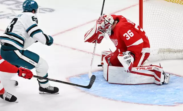Detroit Red Wings goaltender John Gibson, right, stops a shot from San Jose Sharks center Zack Ostapchuk during the first period of an NHL hockey game, Saturday, Oct. 17, 2026, in Detroit. (AP Photo/Jose Juarez)