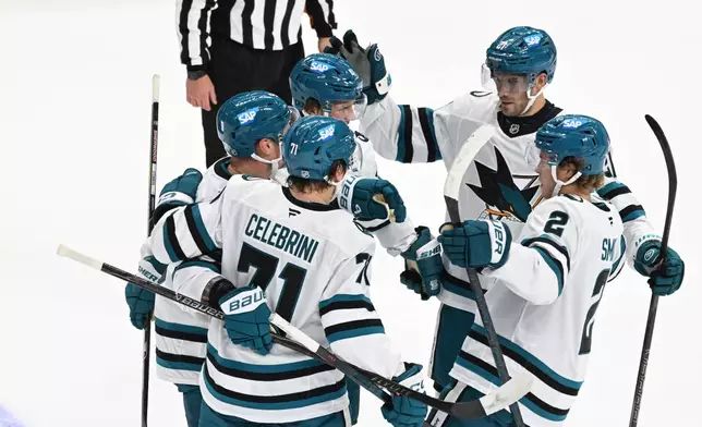 San Jose Sharks defenseman Dmitry Orlov, center left, is congratulated by teammates after scoringh a goal during the first period of an NHL hockey game against the Detroit Red Wings, Saturday, Oct. 17, 2026, in Detroit. (AP Photo/Jose Juarez)