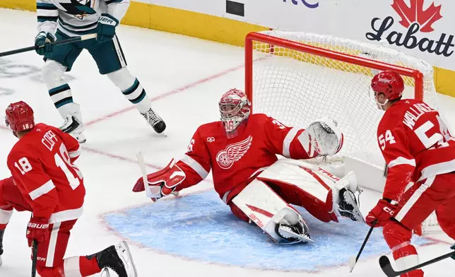 Detroit Red Wings goaltender John Gibson, center, kicks his legs out and makes a save during the first period of an NHL hockey game against the Detroit Red Wings, Saturday, Oct. 17, 2026, in Detroit. (AP Photo/Jose Juarez)