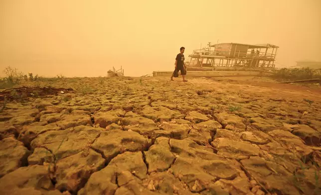 A man walks amid thick haze from wildfires in Palangkaraya, Central Kalimantan, Indonesia, Saturday, Oct. 24, 2026. (AP Photo/Yulianus Stefan Lundju)