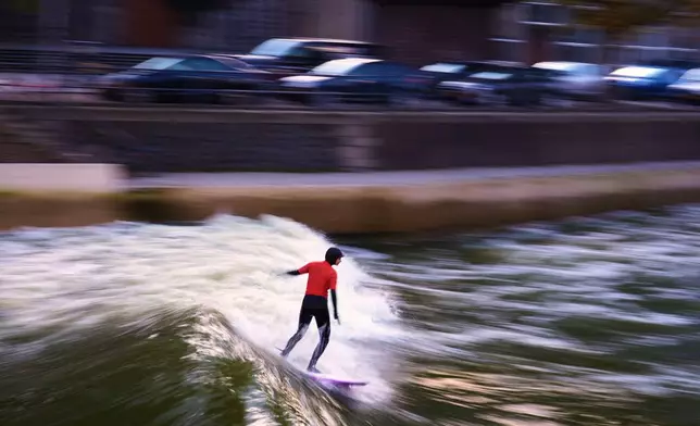 A surfer rides an artificial wave in an urban pool in Rotterdam, the Netherlands, Tuesday, Oct. 20, 2026. (AP Photo/Francisco Seco)