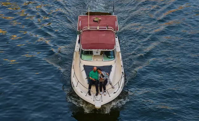 A couple enjoy a boat ride through Dubai Marina in Dubai, United Arab Emirates, Saturday, Oct. 24, 2026. (AP Photo/Fatima Shbair)