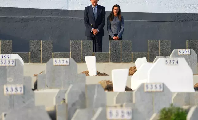 Spain's King Felipe VI and Queen Letizia stand at Sidi Embarek Cemetery, where people who died at sea on July 30 and 31 are buried, during their visit to the Spanish enclave of Ceuta, Tuesday, Oct. 13, 2026. (AP Photo/Manu Fernández)