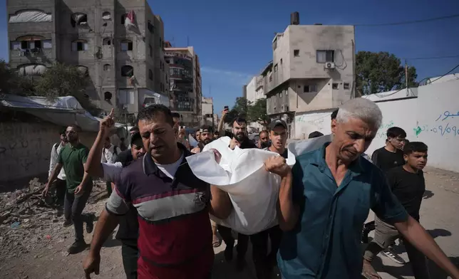 Mourners carry the body of Moamen Alay, who was killed in an Israeli airstrike, during his funeral in Gaza City Tuesday, Oct. 13, 2026. (AP Photo/Jehad Alshrafi)