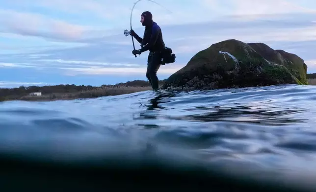 Jason Markowitz casts from an offshore rock while fishing for striped bass, Saturday, Oct. 10, 2026, in Montauk, N.Y. (AP Photo/Robert F. Bukaty)