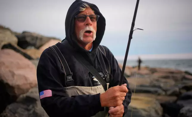 John Mahan takes a break from casting at Montauk Point on Sunday, Oct. 11, 2026, (AP Photo/Robert F. Bukaty)